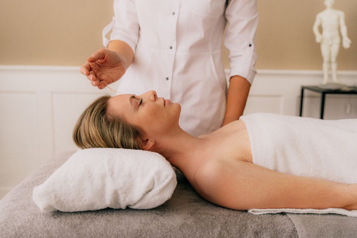 Chiropraxie Deconiac A woman receiving a relaxing acupuncture session on a massage table indoors.